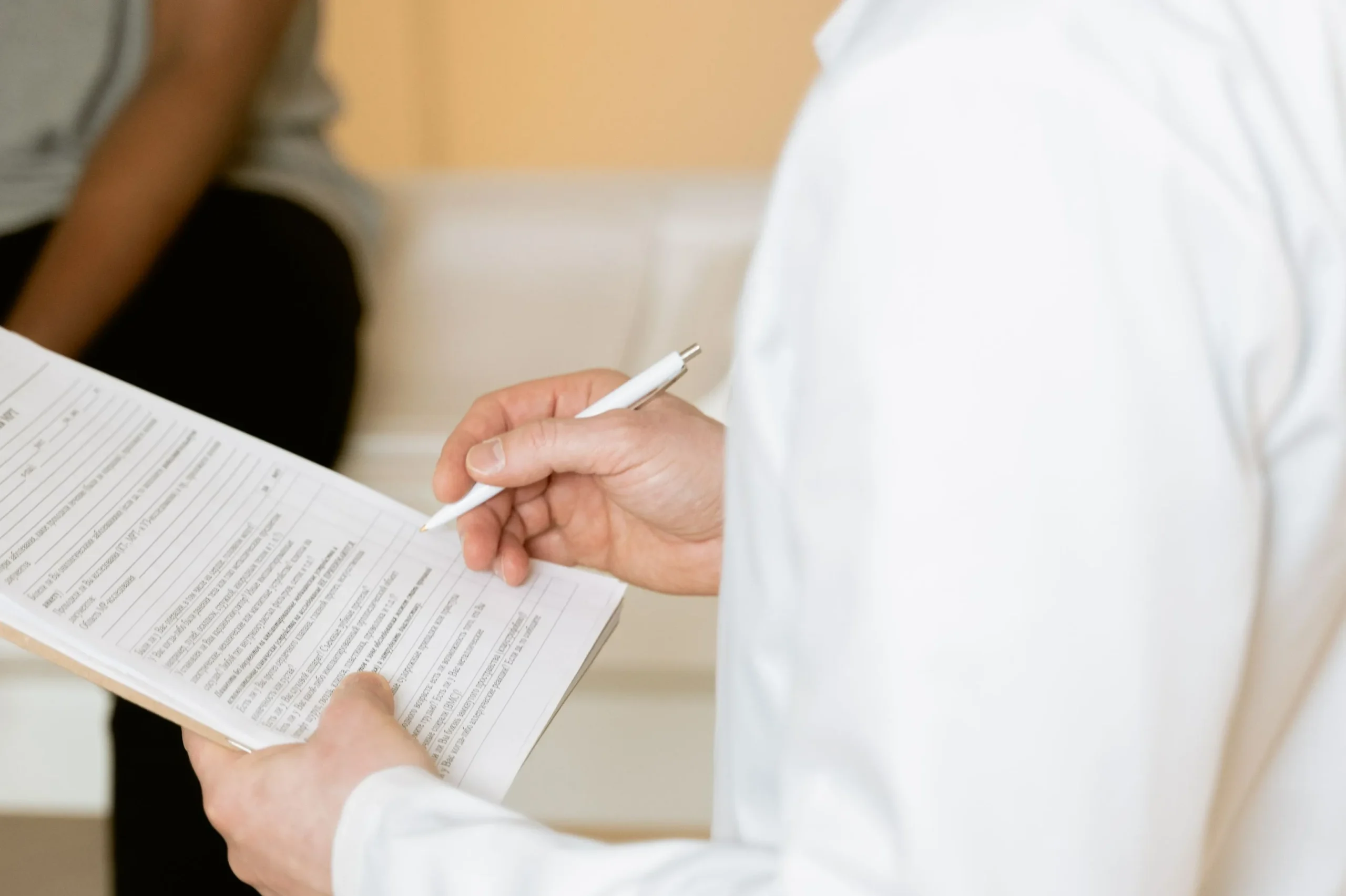 Practitioner reviewing consultation notes before a non-surgical rhinoplasty assessment.